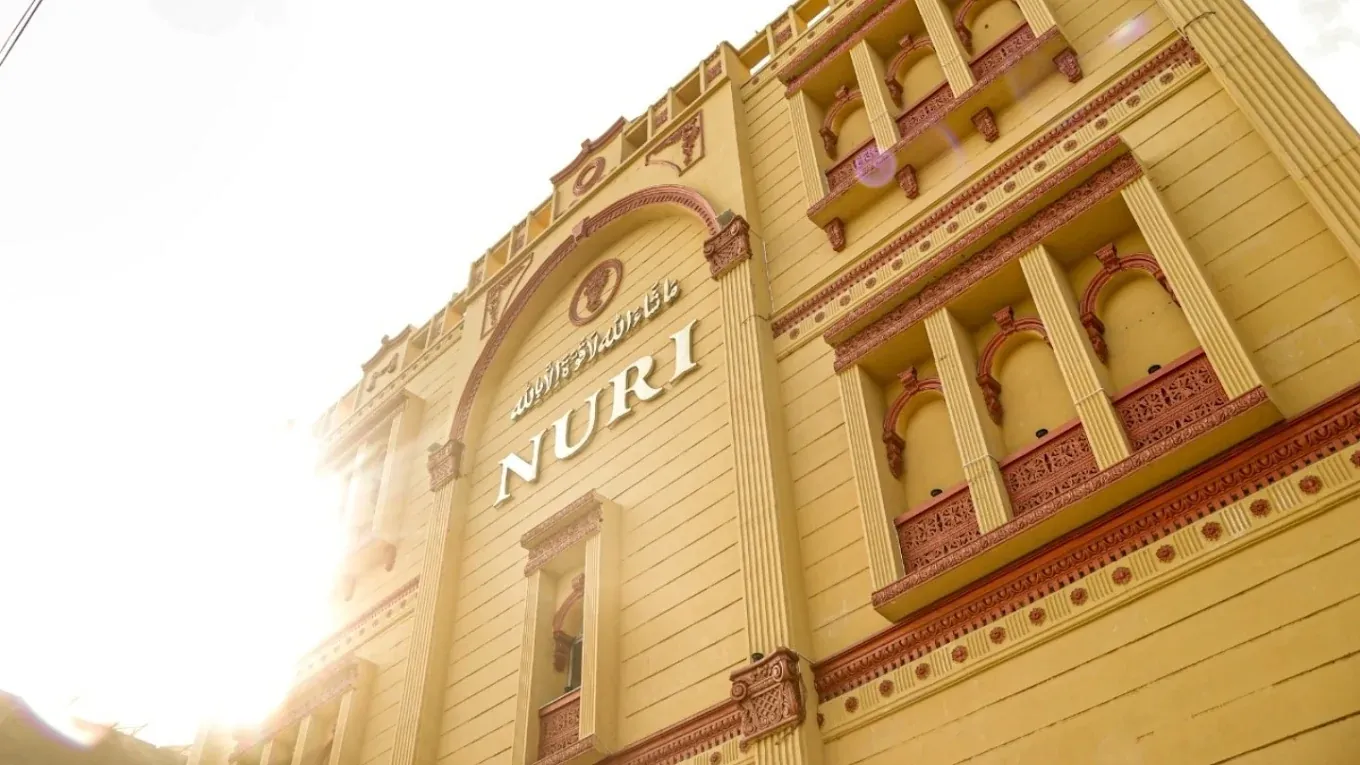Golden NURI building facade with carved terracotta balconies