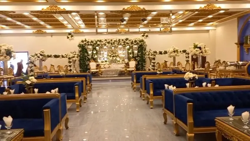 Wide view of the hall with velvet sofas and floral centrepieces